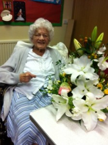 A group member receives flowers to celebrate her 100th birthday