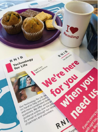 A mug, cakes and biscuits and RNIB leaflets.
