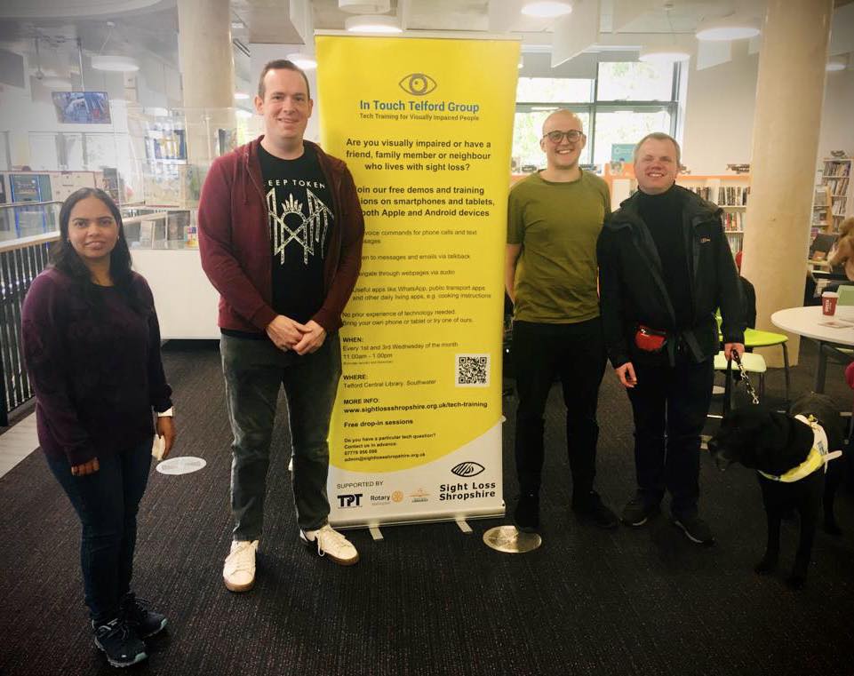 Tech trainer volunteers from CapGemini standing next to the In Touch Telford banner at Southwater Library, Telford. 