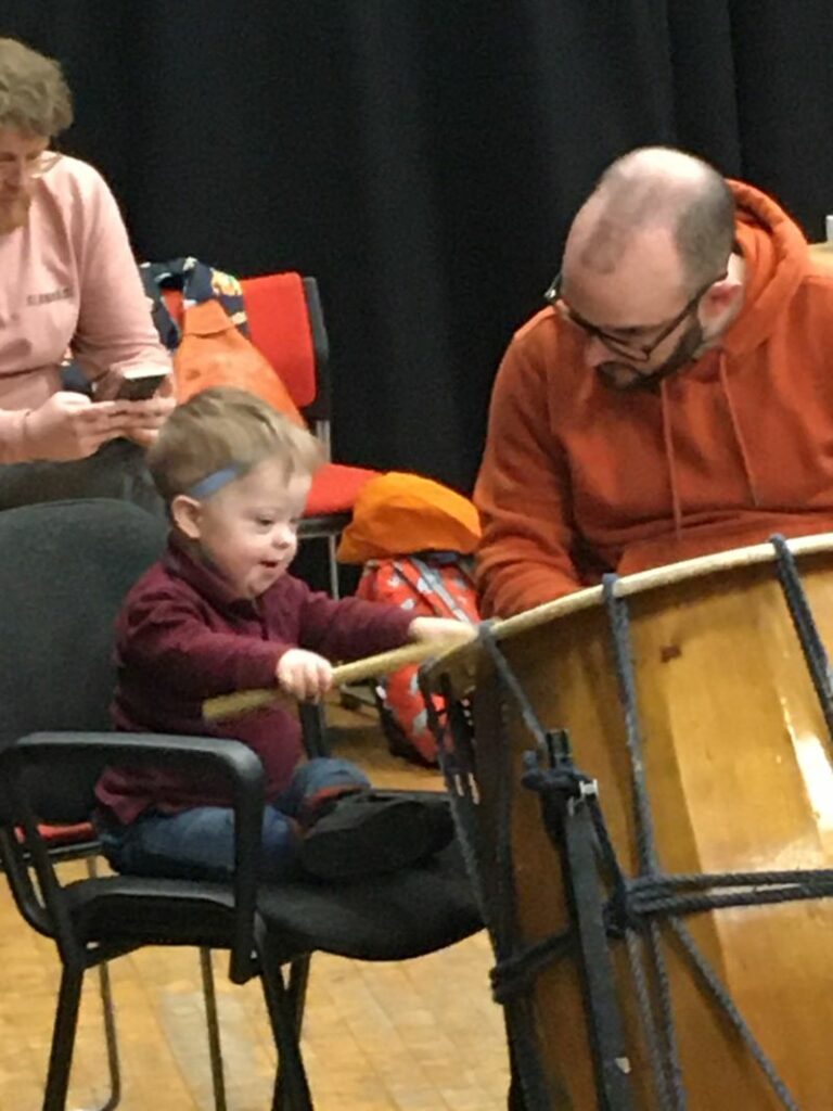A young child using large Japanese drums